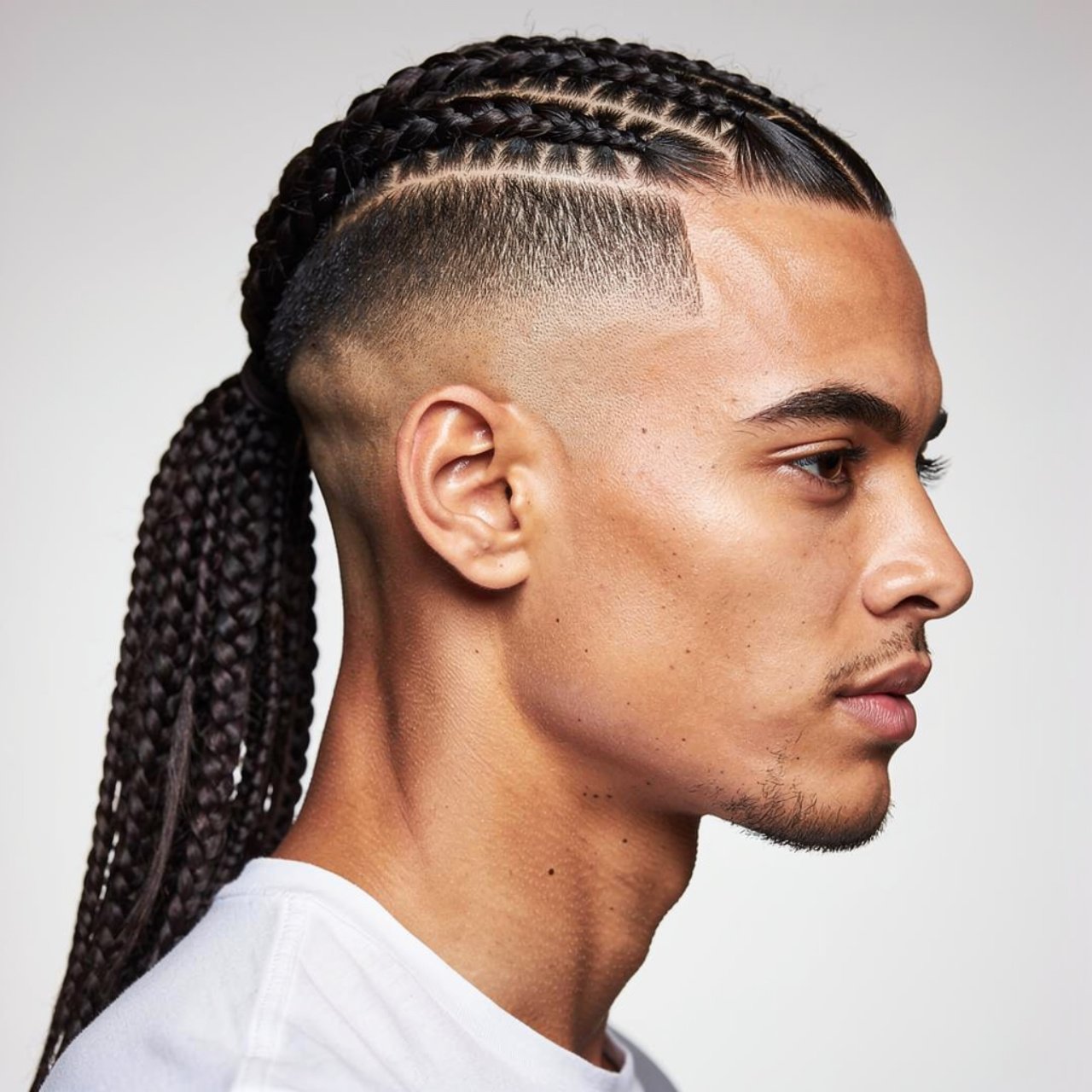 single portrait of a stylish man with a braided po