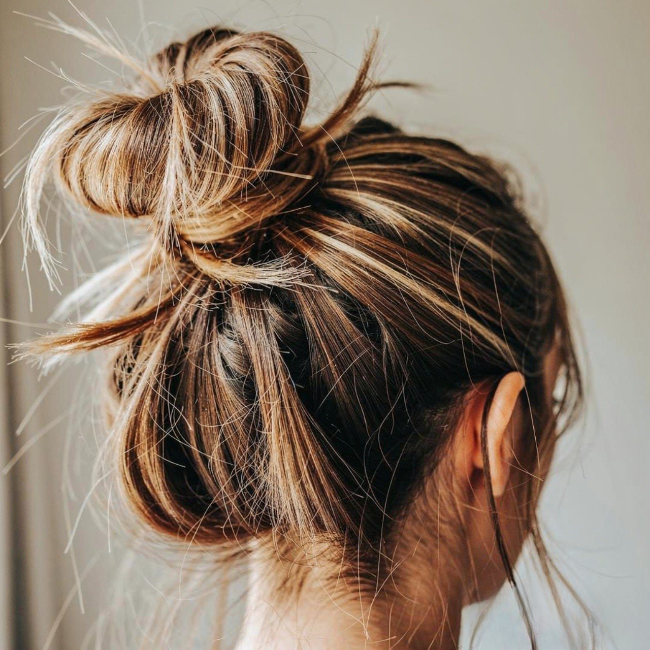 messy bun with loose strands summer hairstyle sing