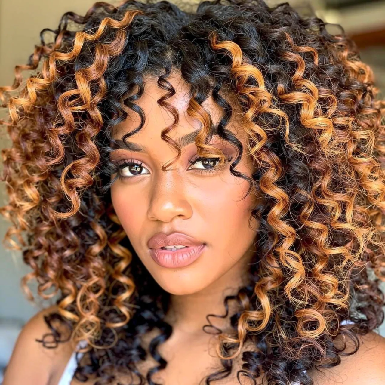 16 Trendy Curly Hair Color Ideas for Every Curl Type 9 portrait of a person with chunky two tone highligh